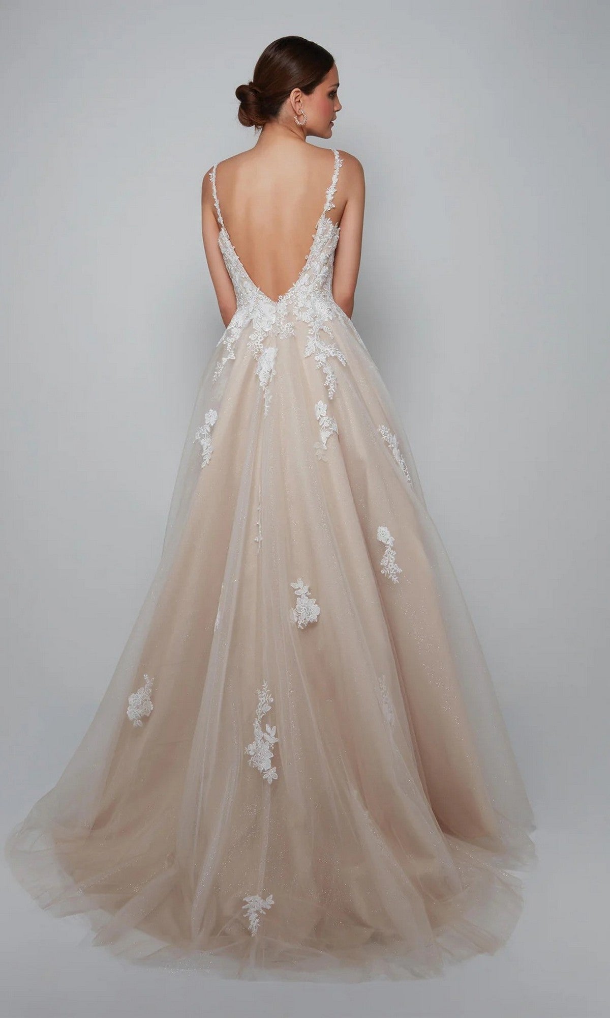 Woman wearing the Alyce 7084 long white dress, a sleeveless and backless bridal ball gown with a sweetheart neckline, lace appliqués, and a full tulle skirt, poses against a plain light background.